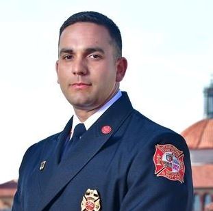 Headshot photo of Fire Chief Carlos Aviles with Flagler College tower in the background